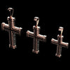 Three silver cross pendants with textured, ribbed details and looped bail tops, displayed against a solid black background.