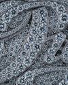 Close-up of a silver-toned jewelry piece densely set with round brilliant-cut diamonds, showing the sparkle and metallic outline against a matching diamond-covered background.