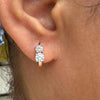 Close-up of an ear wearing a rose gold and diamond earring.
